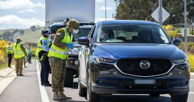 Lance Corporal Mancell Laidler, of Joint Task Group 629.9, inspects the licence of a motorist at the ACT Federal Highway border-control point during Operation COVID-19 Assist. Photo by Corporal Jarrod McAneney.