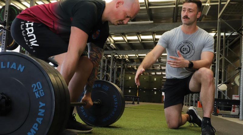 Australian Army avionics technician Corporal Simon Camilleri from 5th Aviation Regiment coaches a soldier through strength and conditioning techniques as a Combat Fitness Leader at RAAF Base Townsville, Queensland. Story by Captain Carolyn Barnett. Photo by Lance Corporal Lisa Sherman.