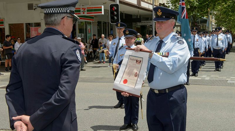 Warrant Officer John Markham, the parade Warrant Officer presents Assistant Commissioner Allan Adams with the Freedom of Entry scroll during No. 25 Squadron's Freedom of Entry parade in the City of Perth, Western Australia. Story by Flying Officer Robert Hodgson. Photo by Sergeant Gary Dixon.