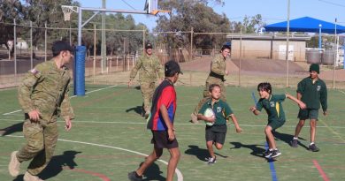 Private Robert Bayley, Corporal Jake Cobb and Private Harrison Britt play touch football with children at the Cunnamulla Breakfast Club. Story by Captain Pete Conrad .