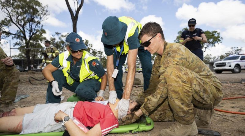 A soldier from the 3rd Combat Engineer Regiment helps Queensland Ambulance Service paramedics during a mass casualty scenario at Townsville field training area. Story by Captain Diana Jennings. Photo by Corporal Brandon Grey.