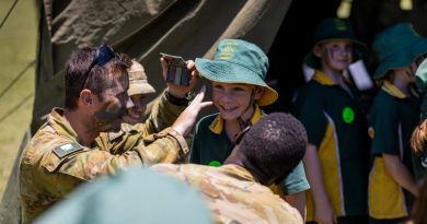 Soldiers from the 7th Combat Signal Regiment apply camouflage cream to a student at Gympie East State School. Story by Captain Jesse Robilliard . Photo by Patrick Maher.