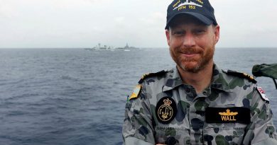 HMAS Warramunga's principal warfare officer and former Royal Canadian Navy officer, Lieutenant Commander Stephen Wall, with his former ship HMCS Winnipeg and HMAS Brisbane in the background. Photo by Petty Officer Yuri Ramsey.