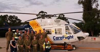 Members from the 3rd Health Support Battalion join Captain Paul Hanley (top, second from left), Ruth Parsell (bottom, first from left) and pilot Ian Smart (bottom, first from right) in front of the CareFlight rapid response helicopter. Story by Flight Lieutenant Nick O’Connor. Photo by Duyen Nguyen.