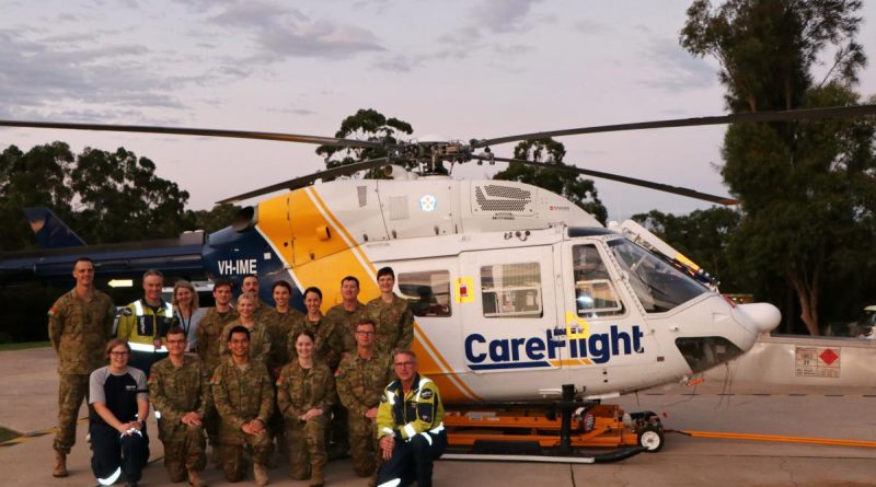 Members from the 3rd Health Support Battalion join Captain Paul Hanley (top, second from left), Ruth Parsell (bottom, first from left) and pilot Ian Smart (bottom, first from right) in front of the CareFlight rapid response helicopter. Story by Flight Lieutenant Nick O’Connor. Photo by Duyen Nguyen.
