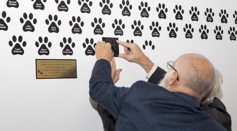 RAAF Dog Handlers Association members Ray Thomas, right, and Kim Hodgeo add another member's name to the RAAF Dog Handlers Association wall of remembrance at the RAAF Security and Fire School, RAAF Base Amberley. Story by Flight Lieutenant Julia Ravell. Photo by Leading Aircraftwoman Emma Schwenke.