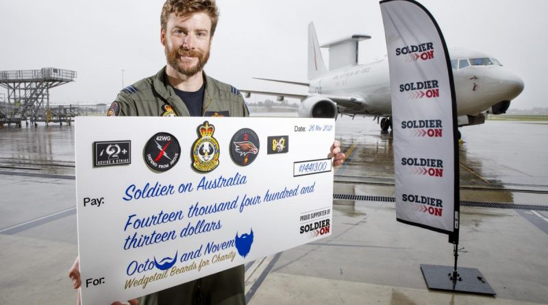 Flight Lieutenant Brendan Campbell with a cheque for funds raised for Soldier On. Story by Flight Lieutenant Brendan Campbell. Photo by Corporal Craig Barrett.