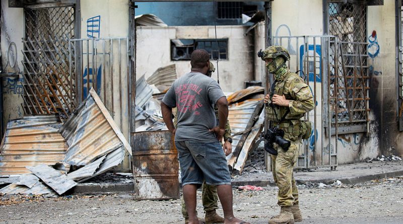 Australian Army Corporal Brodie Cross from Joint Task Group 637.3 talks with a local man in Honiara, Solomon Islands, on 02 December 2021. Photo by Corporal Brandon Grey.