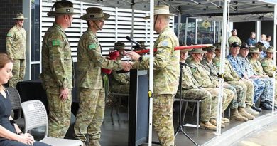 Outgoing Commander 1st Division Major General Jake Ellwood, centre, accepts the 1st Division pennant from Regimental Sergeant Major Warrant Officer Class One Michael Landy during the command handover parade. Story by Lieutenant Simon Hampson. Photo by Sergeant Kerry Uilderks.