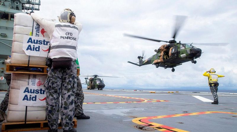 A MRH-90 Taipan launches from the flight deck of HMAS Adelaide to drop disaster relief supplies to Nabouwalu on the island of Vanua Levu, Fiji, during Operation Fiji Assist. Story by Captain Jessica O’Reilly. Photo by Corporal Dustin Anderson.