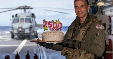 Lieutenant Michael Wisniewski receives a cake on board HMAS Brisbane after he clocked up 2500 career flying hours. Story and photo by Leading Seaman Daniel Goodman.