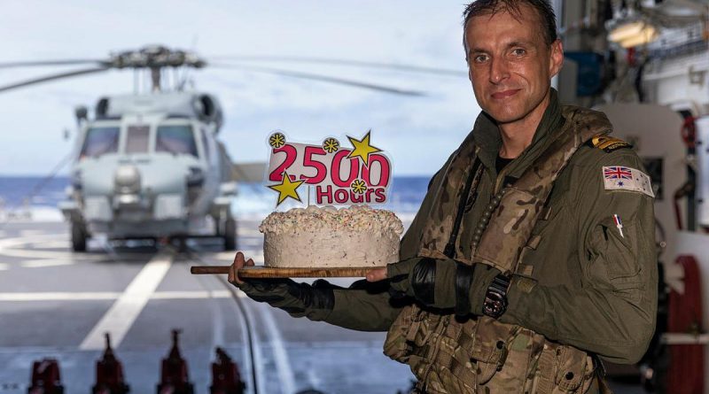 Lieutenant Michael Wisniewski receives a cake on board HMAS Brisbane after he clocked up 2500 career flying hours. Story and photo by Leading Seaman Daniel Goodman.