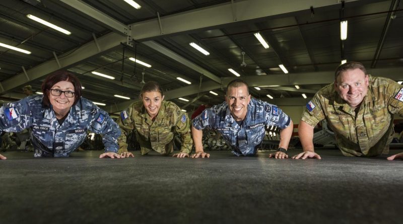 Air Force aviator Warrant Officer Raylee Scott (left) taking part in the Million Push-Up Challenge with Theatre Communications Group colleagues while deployed to the Middle East. Story by Flight Lieutenant Jessica Aldred. Photo by Corporal David Cotton.