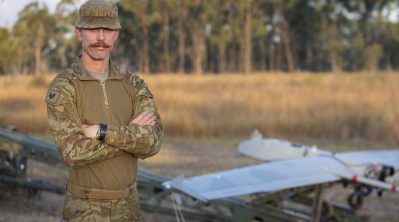 Sergeant Marc Plant stands in front of a Shadow 200 UAS. Photo by Petty Officer Lee-Anne Cooper.