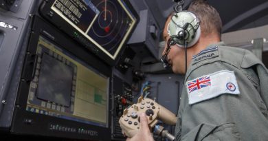 RAAF combat systems officer Flight Lieutenant Cameron McKinnon works at the C-130J Hercules aircraft's augmented crew station to capture imagery of the damage in Tonga. Story by Eamon Hamilton. Photo by Sergeant David Gibbs.