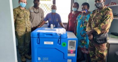 Australian Army officer Captain Jyra Blake-Waller, left, and PNGDF officer Captain Charles Namuesh, right, deliver a solar-powered vaccination fridge to Mumeng Health Centre, Morobe Province, PNG. Photo by Captain Nathanael Kennedy.