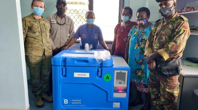 Australian Army officer Captain Jyra Blake-Waller, left, and PNGDF officer Captain Charles Namuesh, right, deliver a solar-powered vaccination fridge to Mumeng Health Centre, Morobe Province, PNG. Photo by Captain Nathanael Kennedy.