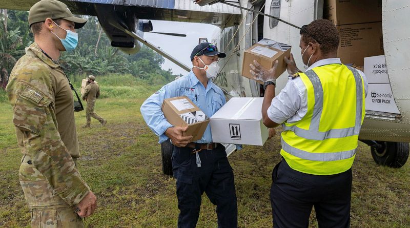 A RAAF combat controller from No. 4 Squadron and Mr Rob Crowell (centre) from the Australian Medical Assistance Team help unload Australian Government critical aid supplies from a Solomon Airlines DHC-6 Twin Otter aircraft at Auki airport, Solomon Islands. Story by Captain Peter March. Photo by Corporal Jarrod McAneney.