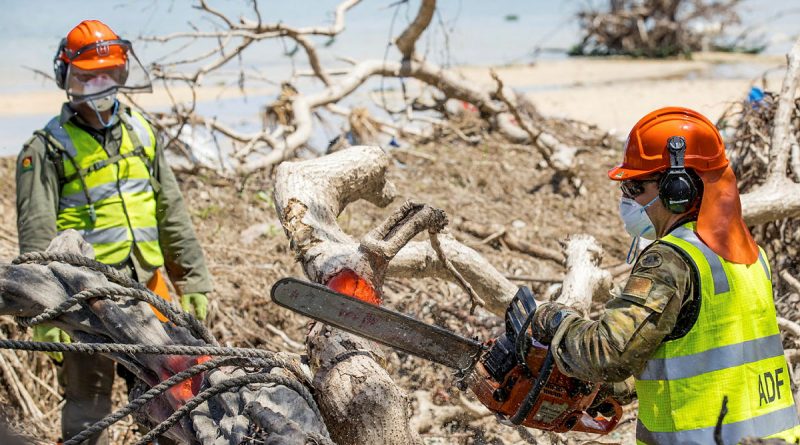 Lance Corporal Kobie Rogers from 2nd Combat Engineer Regiment cuts a fallen tree on Atata Island, Tonga, during Operation Tonga Assist 2022. Story by Lieutenant Brendan Trembath. Photo by Corporal Robert Whitmore.