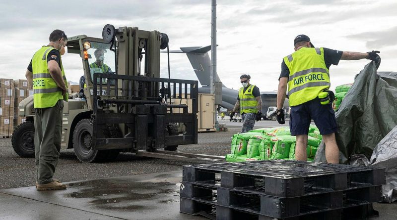 RAAF aviators deployed on Operation Lilia prepare bags of rice before loading them onto C-27J Spartan aircraft for distribution to remote Solomon Islands' provinces. Story by Captain Peter March. Photo by Corporal Jarrod McAneney.