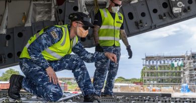 Aircraftsman Sam Schmidt, left, guides a forklift operator while unloading a C-17A Globemaster III aircraft at Honiara International Airport, Solomon Islands. Story by Captain Peter March. Photo by Corporal Jarrod McAneney.