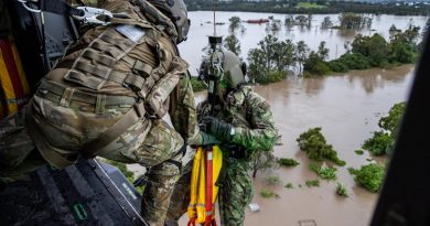 Army Warrant Officer Class Two Benjamin Dwyer from the School of Army Aviation prepares to conduct a rescue by winch of a community member from an MRH-90 Taipan, over Lismore.