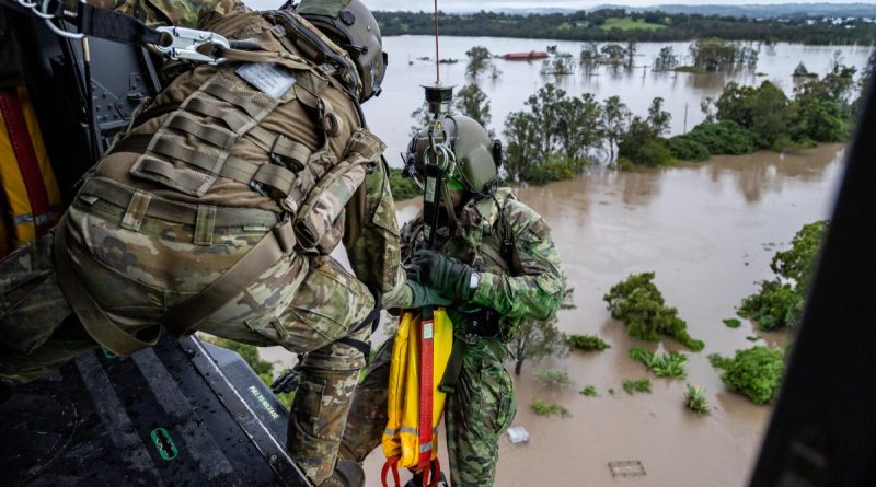 Army Warrant Officer Class Two Benjamin Dwyer from the School of Army Aviation prepares to conduct a rescue by winch of a community member from an MRH-90 Taipan, over Lismore.