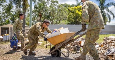 Army soldiers Corporal Joel Down, left, Private Aaron Smith, centre, and Private Zach Quick from 6th Battalion, Royal Australian Regiment, assist Gympie residents clean up. Story by Lieutenant Geoff Long. Photo by Corporal Jonathan Goedhart.