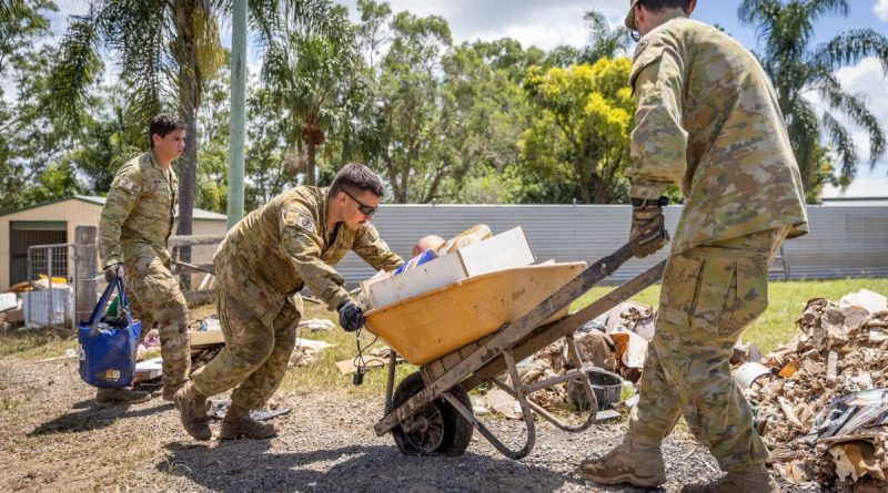 Army soldiers Corporal Joel Down, left, Private Aaron Smith, centre, and Private Zach Quick from 6th Battalion, Royal Australian Regiment, assist Gympie residents clean up. Story by Lieutenant Geoff Long. Photo by Corporal Jonathan Goedhart.
