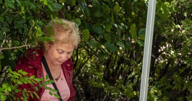 Army Corporal Sebastian Evens (odd camera - right) from 6th Battalion, Royal Australian Regiment, applies a bandage to St Lucia resident Ms Ann Mckenzie. Story by Lieutenant NIc Hawkins. Photo by Corporal Nicole Dorrett.