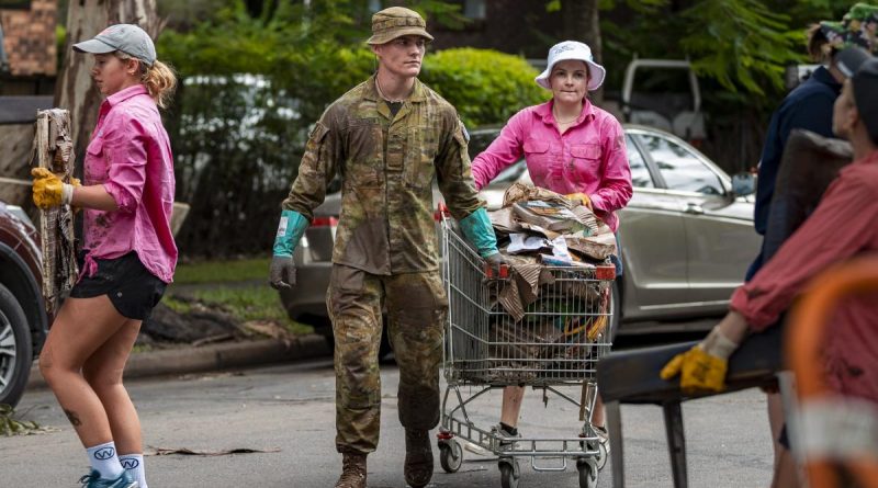 An Australian Army rifleman from 6th Battalion, Royal Australian Regiment, assists the local community to move flood-damaged belongings in St Lucia, Brisbane, during Operation Flood Assist 2022. Story by Lieutenant Nic Hawkins. Photo by Corporal Nicole Dorrett.