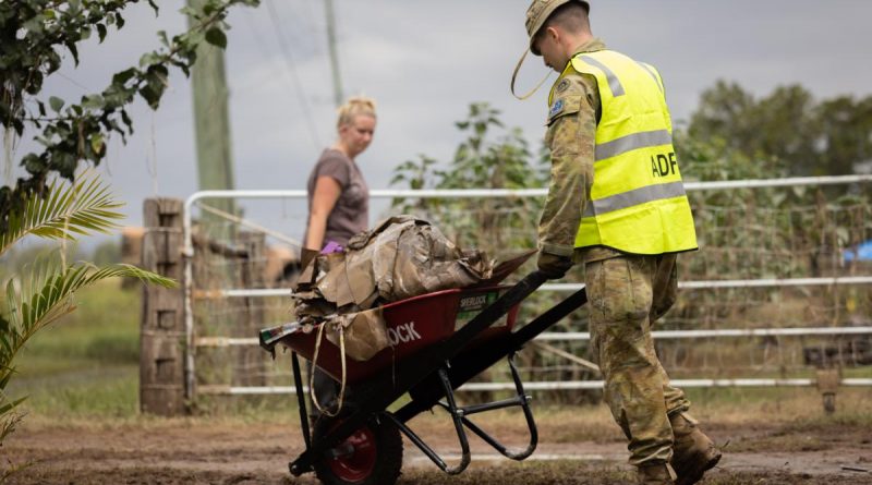 An Australian Army soldier from the 2nd / 14th Light Horse Regiment (Queensland Mounted Infantry), clears flood damage debris from houses in Gatton, Queensland. Story by Lieutenant Geoff Long. Photo by Corporal Jonathan Goedhart.