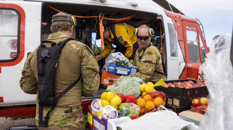 Sergeant Jody Cropp from 41st Battalion, Royal New South Wales Regiment loads crates of fresh food onto a helicopter operated by New South Wales Rural Fire Service, ready for delivery to areas of Northern NSW. Story by Major Jesse Robilliard. Photo by Corporal Dustin Anderson.