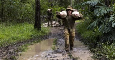 An Army officer from 7th Brigade carries sandbags across a flooded section of trail to repair flood-damaged access tracks in Imbil, Queensland, as part of Operation Flood Assist 2022. Story by Flight Lieutenant Tanya Carter. Photo by Corporal Julia Whitwell.