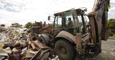 An Army soldier uses a backhoe to clear flood-damaged household goods from a street in Lismore, as part of Operation Flood Assist 2022. Story and photo by Warrant Officer Class Two Max Bree.