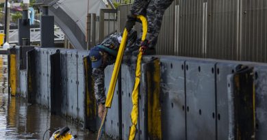 Navy divers Chief Petty Officer Cameron Schmid, right, and Able Seaman Jordan Bitolkoski, centre, assist Able Seaman Jake Phillips as he surveys ferry terminals pylons along the Brisbane River. Story by Private Jacob Joseph. Photo by Corporal Julia Whitwell.