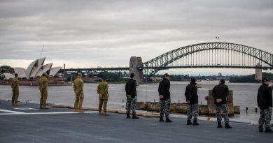 Australian Defence Force personnel on HMAS Adelaide line the flight deck as the ship returns to her home port of Fleet Base East in Sydney following a deployment on Operation Tonga Assist 2022. Story by Lieutenant Max Logan. Photo by Petty Officer Christopher Szumlanski.