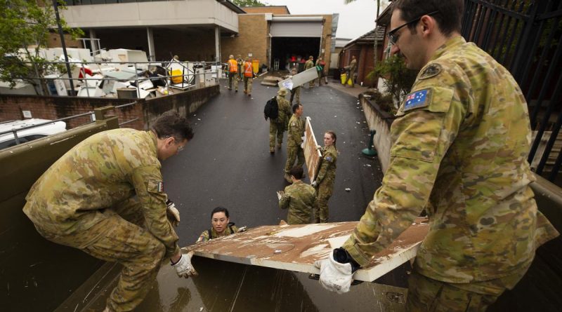 Army soldiers Sapper Callan Stuart, left, and Sapper Ben Lowe, right, load flood-damaged furniture and equipment from Lismore police station in northern NSW onto a truck. Story by Captain Annie Richardson. Photo by Warrant Officer Class Two Max Bree.