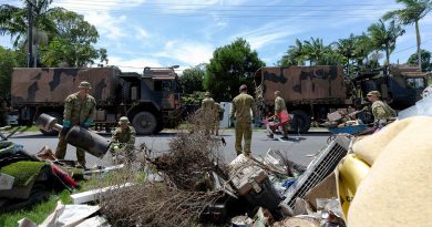 Australian Army soldiers from 6th Battalion, Royal Australian Regiment, collect flood-damaged household items for loading onto a truck as they clear a street in Chinderah, New South Wales. Story by Captain Annie Richardson. Photo by Warrant Officer Class Two Max Bree.