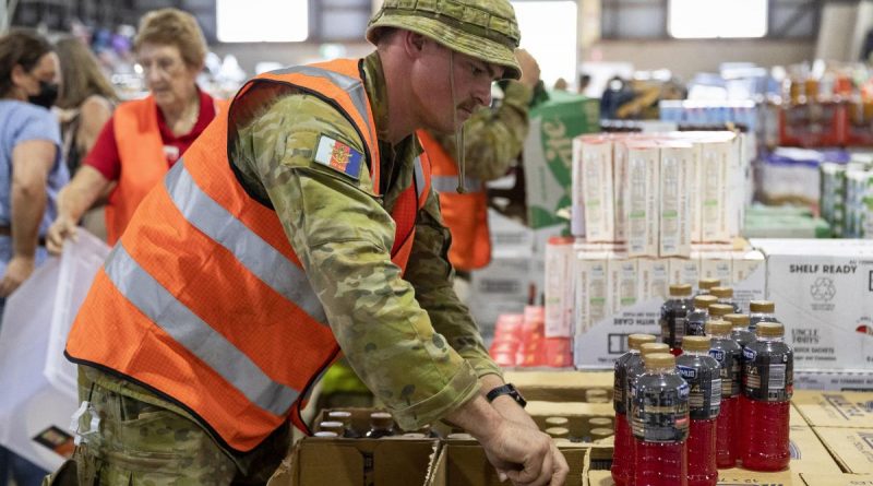 Private Darren Loveday assists volunteers sort essential supplies donated for flood-affected community members at the Lifeline distribution centre in Lismore. Photo by Leading Seaman Kylie Jagiello.