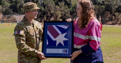 Sergeant Brad Wilson presents an Australian National Flag found in flood debris at Brassall to Ipswich City Mayor Teresa Harding during her visit to Colleges Crossing recreation reserve in Ipswich. Story by Captain Taylor Lynch. Photo by Corporal Nicole Dorrett.