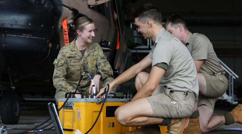 Captain Elise McKenzie, from 5th Aviation Regiment, talks to soldiers conducting maintenance on an MRH-90 Taipan at RAAF Base Townsville. Story by Captain Carolyn Barnett. Photo by Corporal Lisa Sherman.