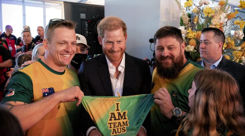 Invictus Games Team Australia competitors Matt Model (left) and Damien Irish (right) gift a pair of Team Australia swimmers to Prince Harry, The Duke of Sussex. Story by Lucy Redford-Hunt. Photo by Flight Sergeant Ricky Fuller.