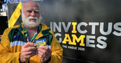 Proud father of Australian Invictus Games 2020 competitor and Royal Australian Navy sailor Leading Seaman Chris Reck, Bob Reck holds up a patch supporting Ukraine at Invictus Games Park in The Hague. Story and photo by Tina Langridge.