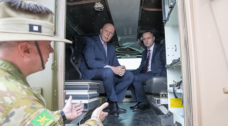 Minister for Defence Peter Dutton sits inside a Bushmaster protected mobility vehicle with Ukrainian Ambassador to Australia Vasyl Myroshnychenko, talk to Commander of 1st Division Major General Scott Winter at RAAF Base Amberley, just before the protected mobility vehicle was flown to Ukraine to assist in their war effort against Russia. Photo by Kym Smith.