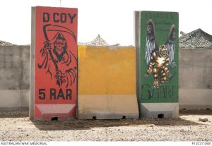 T-Wall murals representing D Company, 5th Battalion, Royal Australian Regiment (5 RAR) and 2nd Cavalry Regiment (2 Cav Regt) Sabre Squadron, 'Charlie V Snoop Troop', Camp Terendak, Ali Air Base, southern Iraq. One of a series of photographs taken by Mike Cecil, Head of Military Heraldry and Technology, as part of the Memorial's Curators in the Field program. Mike travelled to Iraq in May 2008 to record the early stages of withdrawal of the Overwatch Battle Group (West) (OBG-W) before the cessation of combat operations in June 2008. Photographs, oral histories and objects were collected to document the experience of Australian Defence Force personnel during Operation CATALYST.