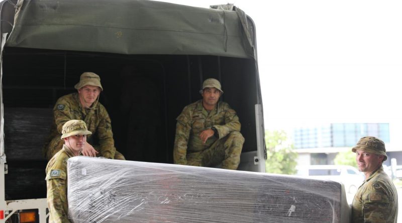 From left, Sergeant Gareth Burrows, Private Rhys McBride, Private Omid Sharifi and Craftsman Ashley Doyle load donated furniture into one of the trucks. Story by Captain Annie Richardson. Photo by Sergeant Jason Slape.