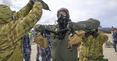 Aviators from No 381 and No. 1 Security Forces Squadrons guide a pilot with protective clothing through the decontamination processes during Exercise Toxic Safari at RAAF Base Amberley. Story by Flight Lieutenant Robert Hodgson. Photo by Corporal Brett Sherriff.