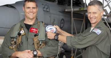Commander Air Combat Group Air Commodore Timothy Alsop (right) presents Squadron Leader Daniel Grealy with an oversized replica patch on attaining 4000 flying hours in F/A-18 type aircraft at RAAF Base Amberley, Queensland. Story by Flight Lieutenant Bronwyn Marchant. Photo by Sergeant Peter Borys.