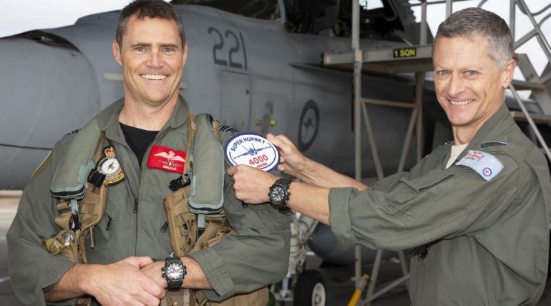 Commander Air Combat Group Air Commodore Timothy Alsop (right) presents Squadron Leader Daniel Grealy with an oversized replica patch on attaining 4000 flying hours in F/A-18 type aircraft at RAAF Base Amberley, Queensland. Story by Flight Lieutenant Bronwyn Marchant. Photo by Sergeant Peter Borys.